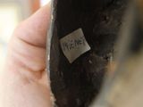 a hand that is holding a shoe with a tag on it