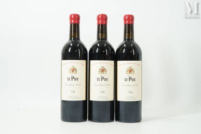 three bottles of red wine are lined up on a white surface
