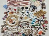 a pile of assorted jewelry on a white surface
