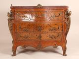 une commode ancienne ornée de sculptures élaborées sur le dessus