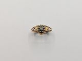 a close up of a gold ring with a black diamond