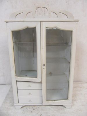une armoire blanche avec une porte vitrée et des tiroirs
