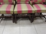 four chairs with pink and green striped upholstered cushions
