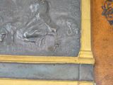 une statue représentant un homme et un chien, fixée sur un mur