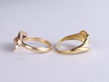 a pair of gold rings on a white surface