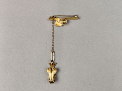 un gros plan d'une broche en or ornée d'un oiseau