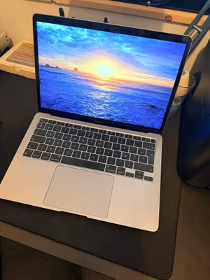 un ordinateur portable posé sur un bureau devant une fenêtre donnant sur l'océan