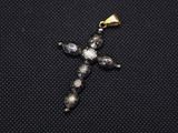 a close up of a cross made of glass beads on a black surface