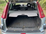 the back of a car with its trunk open on a dirt road