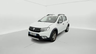 La Dacia blanche est garée dans une pièce blanche au sol blanc.
