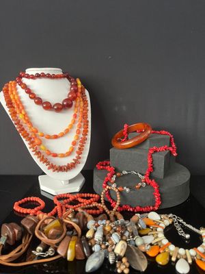 many different necklaces and bracelets displayed on a table