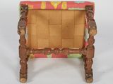 a small wooden chair with a pink and yellow seat