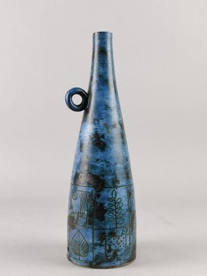 un vase bleu avec une anse noire sur fond blanc