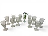 a group of glasses and a vase with flowers in it