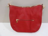 the red purse is sitting on a white table
