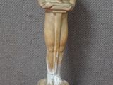 une image représentant une statue d'un homme debout sur un socle en bois