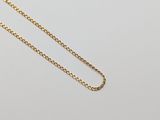 un collier à chaîne en or orné d'un seul diamant sur fond blanc