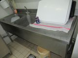 a sink and a trash can in a small kitchen