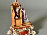 a figurine of a man and a woman sitting on a bench