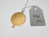 une pièce d'or à laquelle est attachée une étiquette de prix