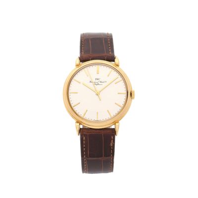 une montre en or avec un bracelet en cuir marron et un cadran blanc