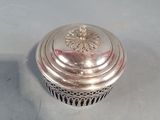 silver plated lidded box with a flower design on the top