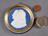 une assiette bleue et dorée sur laquelle figure l'image d'un homme