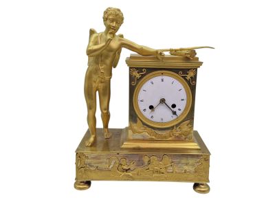 une horloge en or surmontée d'une statue représentant un homme tenant une épée