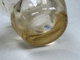 a glass vase with a yellow liquid inside of it