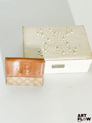 une boîte blanche avec un portefeuille en cuir marron à côté