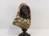 une statue représentant un chien portant une couverture, posée sur une table