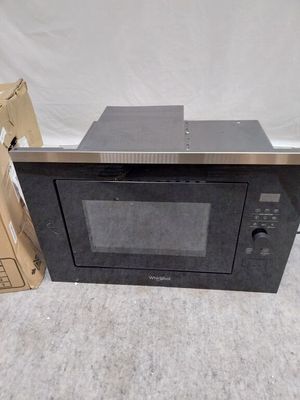 un micro-ondes posé par terre à côté d'un carton