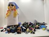 une poupée assise devant une pile de ciseaux