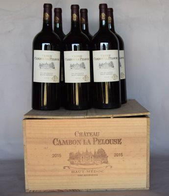 quatre bouteilles de vin se trouvent dans une caisse en bois posée sur une table