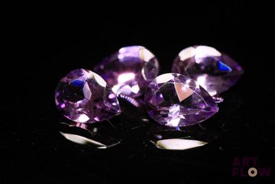 three purple amethtites on a black surface