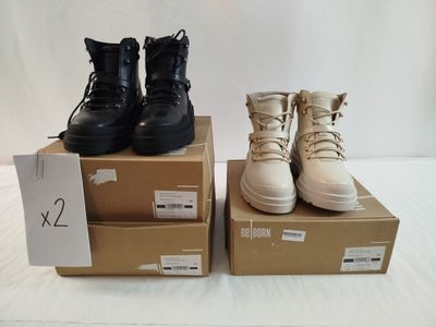 deux paires de bottes de combat noires et fauves posées sur des cartons