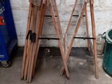 several pieces of wood leaning against a wall next to a trash can