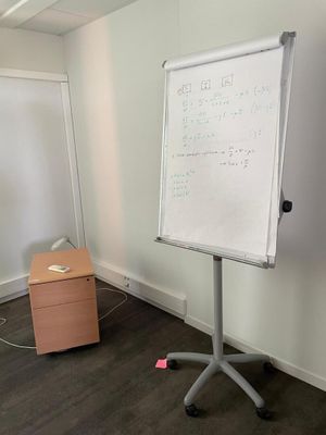 a white board on a stand in the corner of a room