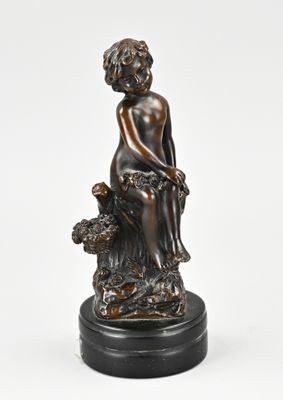 statue en bronze représentant une femme assise sur un rocher avec un chien