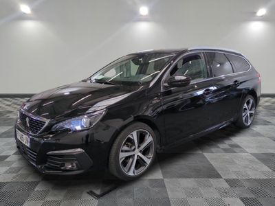 la voiture noire est garée sur un sol en damier dans le garage