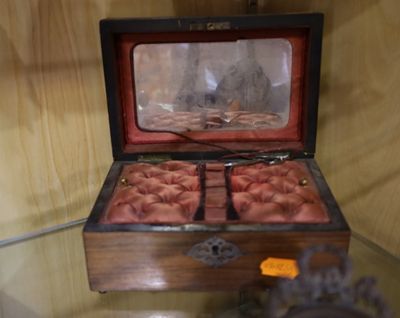 une petite boîte en bois contenant un tas de pièces de monnaie