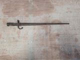 une petite épée posée sur une table en bois