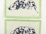 Deux dalmatiens noirs et blancs sont accrochés au mur.