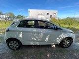 a white car parked in front of a building on a dirt road
