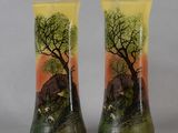 two vases with animals painted on them sitting on a table