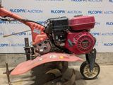 an image of a small lawn mower being used by someone