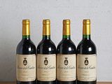 quatre bouteilles de vin sont alignées sur une table en bois