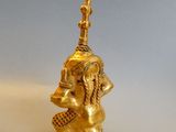 brass figurine of a man with a basket on his head