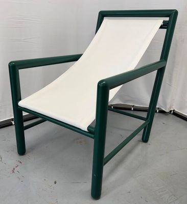 une chaise verte sur laquelle est posé un coussin blanc