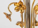 a metal pole with flowers on it and a bird on it